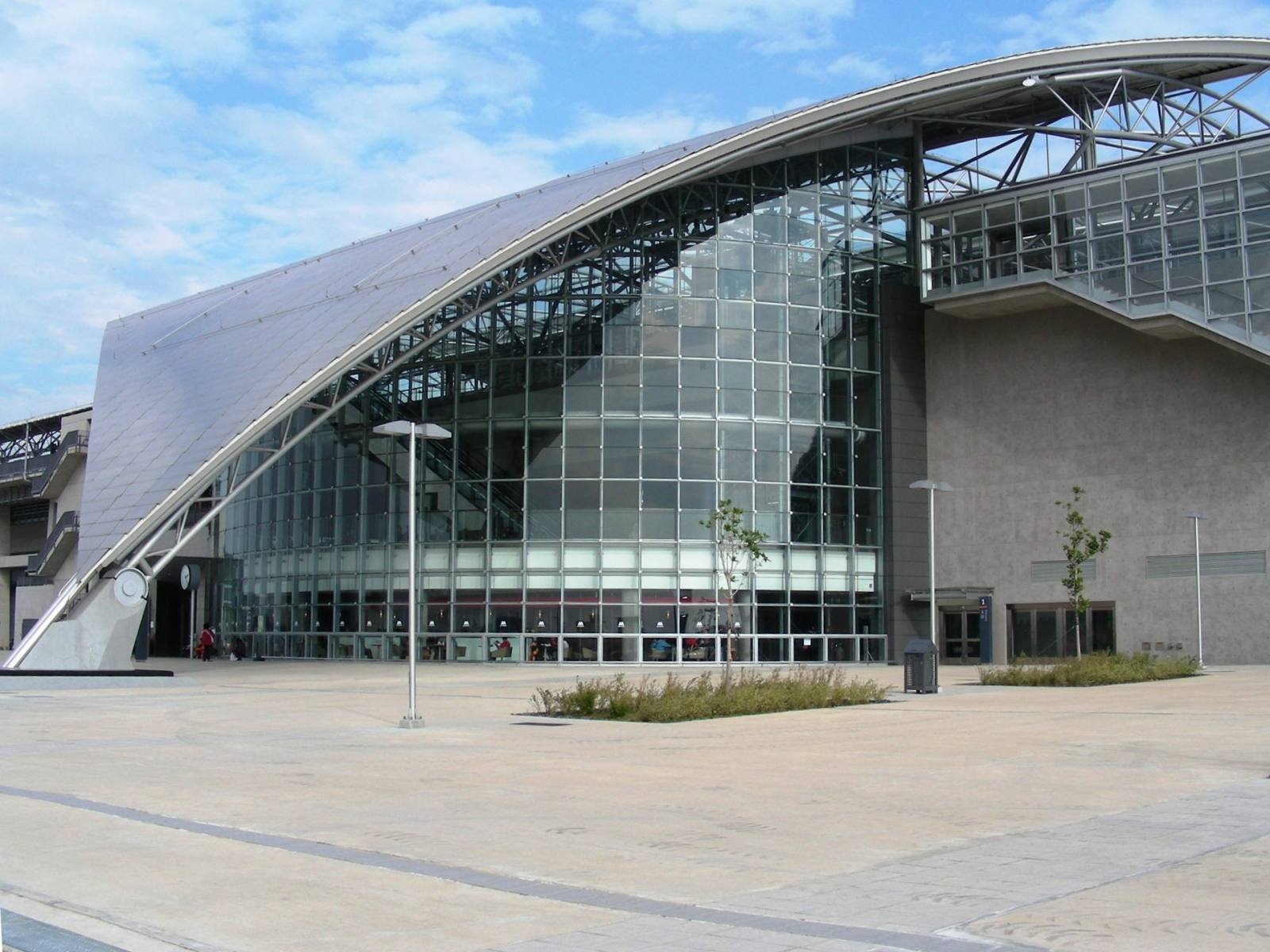 The sweeping curved roof and glass front of the Hsinchu high-speed rail station