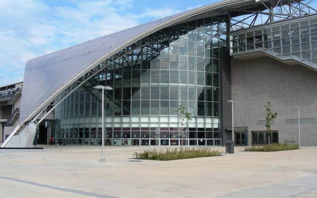 The sweeping curved roof and glass front of the Hsinchu high-speed rail station