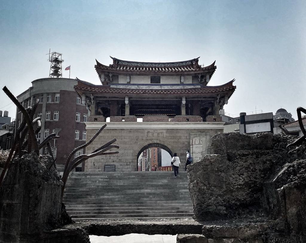 The East Gate of Hsinchu, a two-tiered tower on a stone gateway, with steps down to the sunken plaza