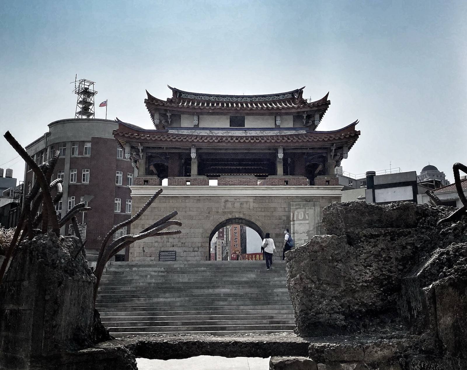 The East Gate of Hsinchu, a two-tiered tower on a stone gateway, with steps down to the sunken plaza
