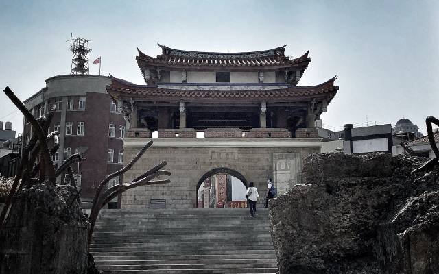 The East Gate of Hsinchu, a two-tiered tower on a stone gateway, with steps down to the sunken plaza