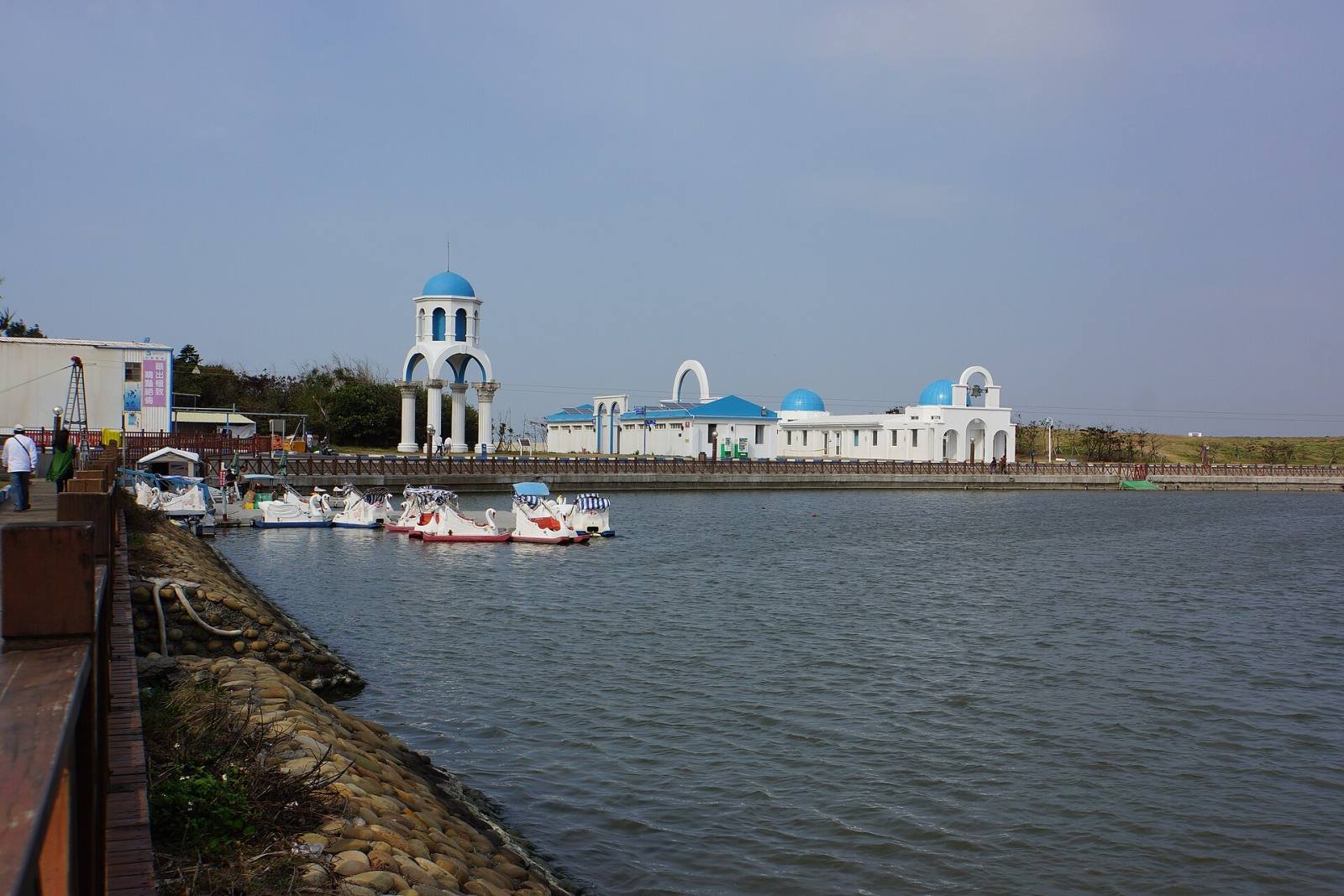 Calm water at Nanliao Fishing Harbour, with white and blue buildings on the far quay