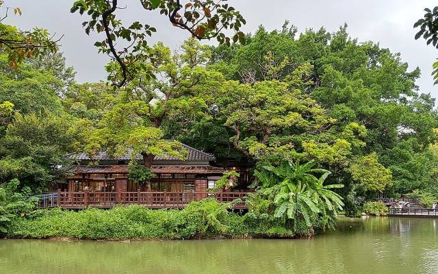 A Japanese-era wooden teahouse beside the lake in Hsinchu Park, among tall trees