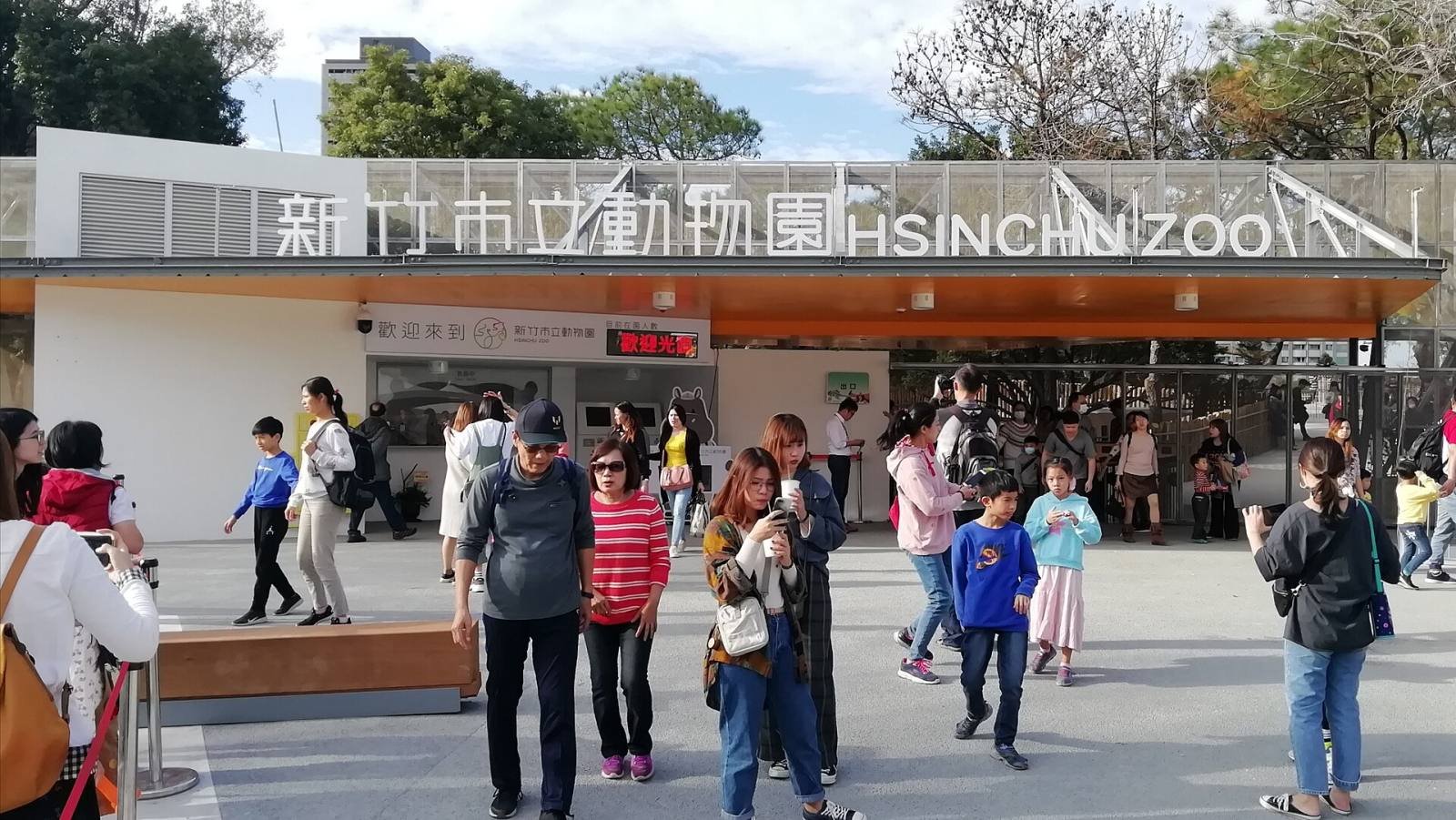Families at the entrance of the Hsinchu Zoo under its green and white sign