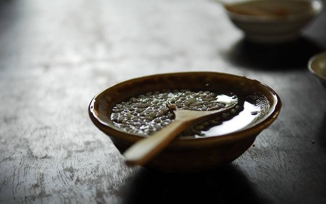 A bowl of lei cha, Hakka pounded tea, with a wooden spoon
