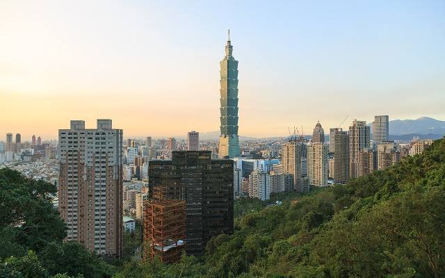 Taipei 101 rising above the city at sunset, seen from the hills